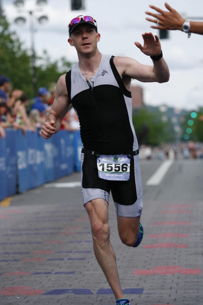 Chris Johnson high-fiving spectators at an Ironman finish