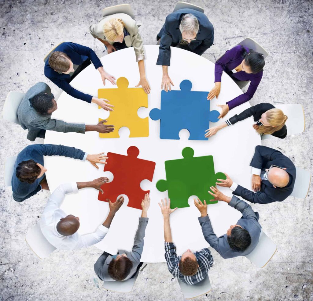 table of people working together to finish puzzle