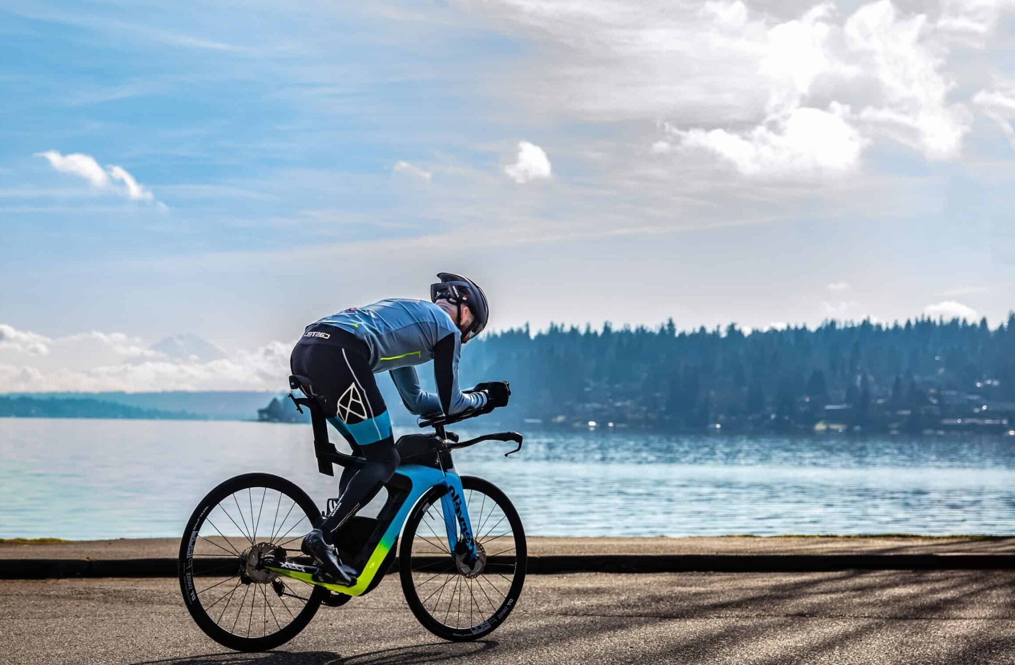 Chris Johnson riding his triathlon bike along the lake